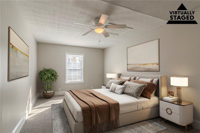 bedroom with ceiling fan, carpet floors, and a textured ceiling