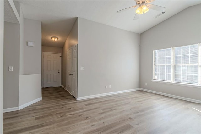 spare room with ceiling fan, lofted ceiling, and light wood-type flooring