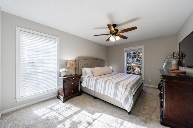 carpeted bedroom featuring ceiling fan and multiple windows