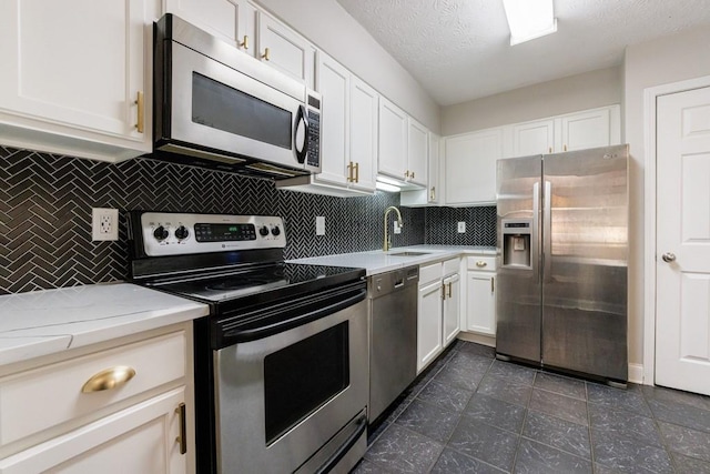 kitchen with sink, decorative backsplash, white cabinetry, and stainless steel appliances