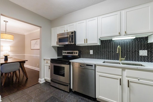 kitchen featuring sink, decorative light fixtures, backsplash, white cabinetry, and stainless steel appliances