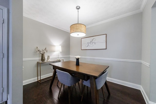 dining space featuring dark wood-type flooring, a textured ceiling, and ornamental molding