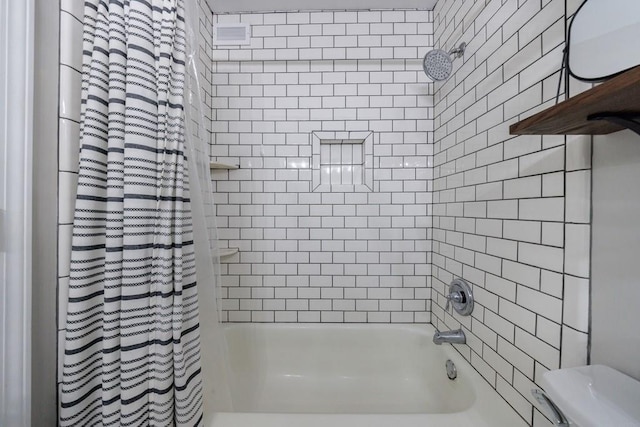 bathroom with shower / bath combo with shower curtain and toilet