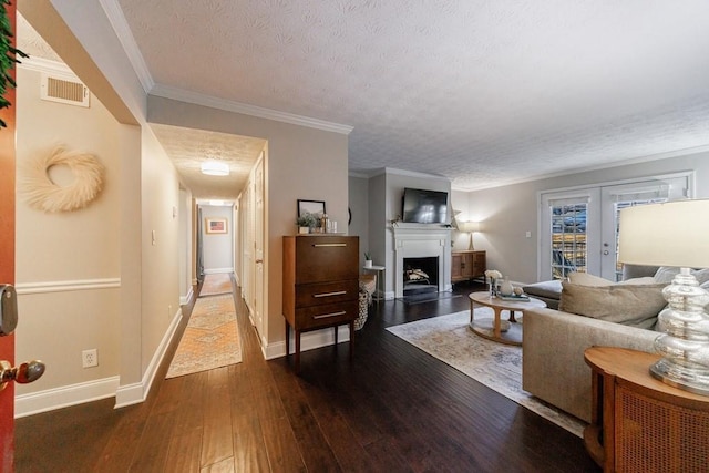 living room with crown molding, dark hardwood / wood-style flooring, a textured ceiling, and french doors