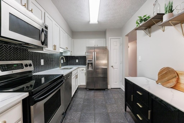 kitchen featuring sink, stainless steel appliances, white cabinets, and a textured ceiling