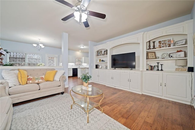 living room featuring ceiling fan with notable chandelier and wood finished floors