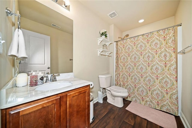 bathroom with visible vents, vanity, toilet, and wood finished floors