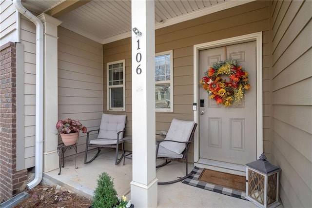 property entrance featuring a porch and brick siding