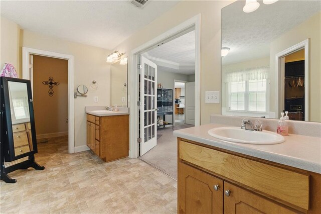 full bathroom with two vanities and baseboards