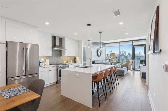788 W Marietta St NW Unit 403, Atlanta, GA 30318 - kitchen featuring wall chimney range hood, high end appliances, modern cabinets, light wood-type flooring, and expansive windows
