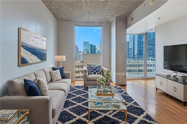 living room with expansive windows, plenty of natural light, and wood finished floors