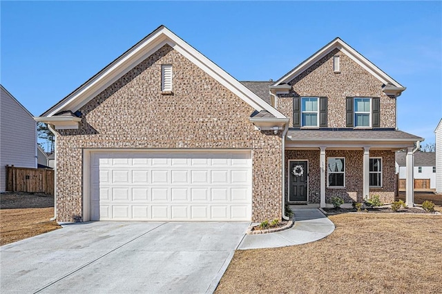 view of front facade with a garage, brick siding, driveway, and fence