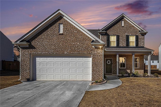 traditional-style home with brick siding, driveway, and an attached garage