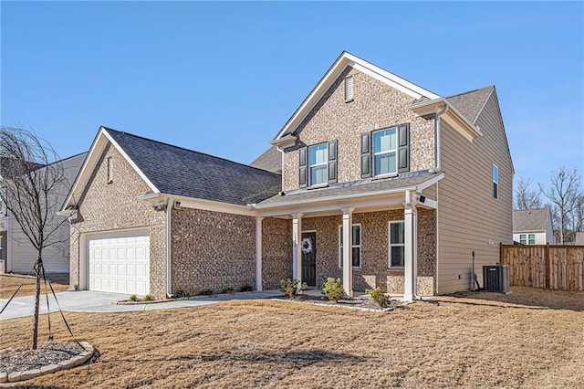 traditional-style house featuring driveway, an attached garage, fence, cooling unit, and brick siding