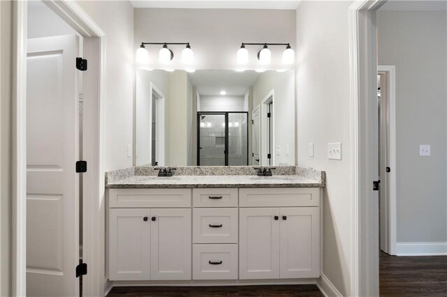 bathroom featuring hardwood / wood-style floors, vanity, and walk in shower