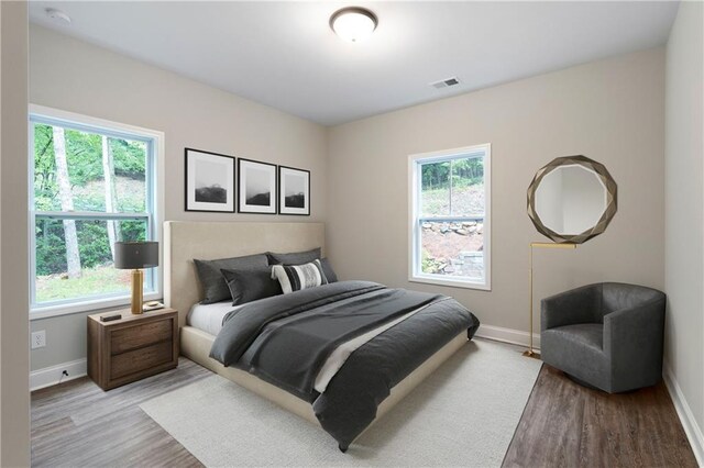 bedroom with light hardwood / wood-style flooring and multiple windows