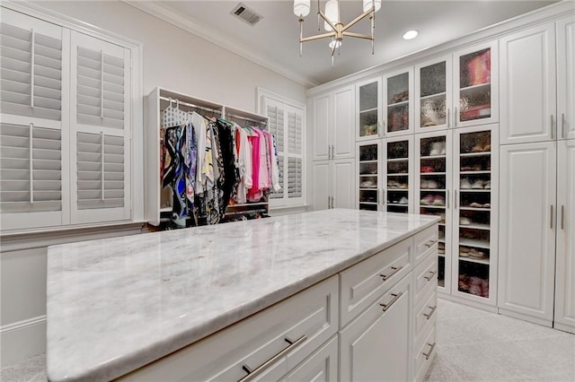 spacious closet with a notable chandelier