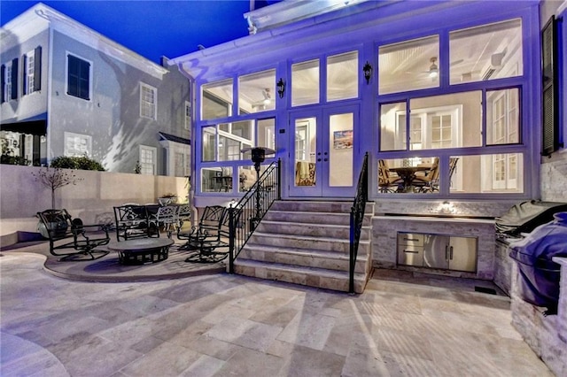 view of exterior entry featuring french doors and a patio area