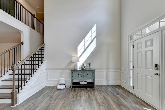 entrance foyer with a towering ceiling and light hardwood / wood-style floors