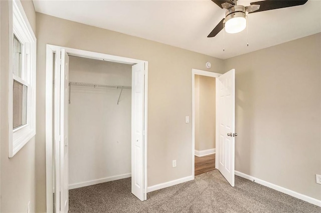 unfurnished bedroom featuring a closet, carpet flooring, a ceiling fan, and baseboards