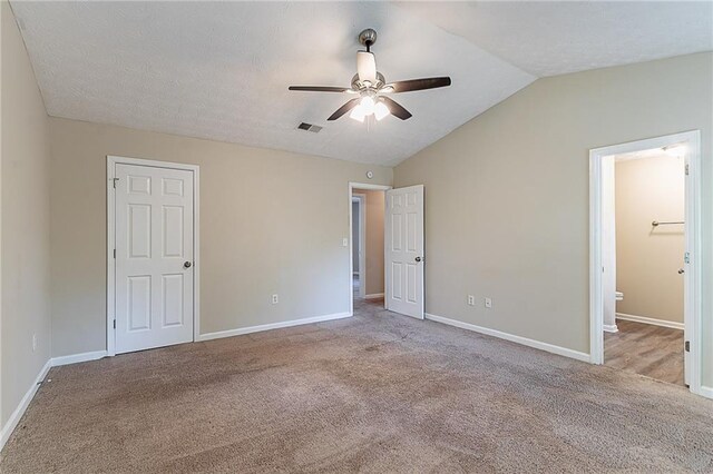 unfurnished bedroom with lofted ceiling, carpet, and baseboards