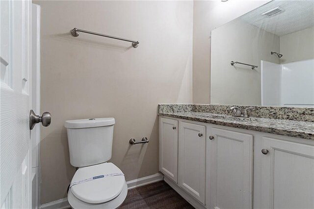 bathroom with vanity, toilet, baseboards, and wood finished floors