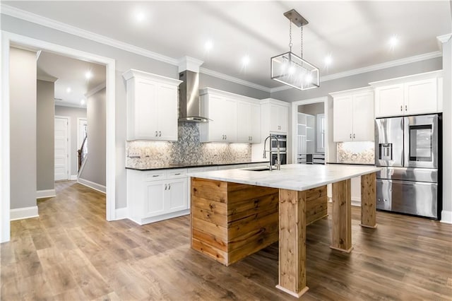 kitchen with wall chimney exhaust hood, white cabinetry, and stainless steel appliances