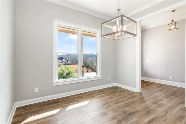 unfurnished dining area with a chandelier, ornamental molding, a healthy amount of sunlight, and wood-type flooring