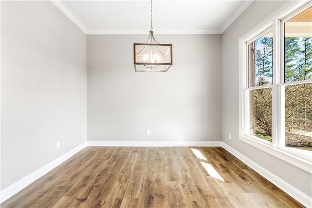 unfurnished dining area featuring a chandelier, wood-type flooring, and ornamental molding