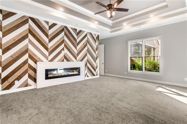 unfurnished living room featuring carpet, a raised ceiling, ceiling fan, and crown molding