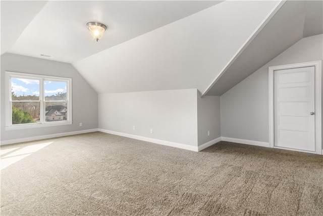 additional living space featuring lofted ceiling and carpet floors