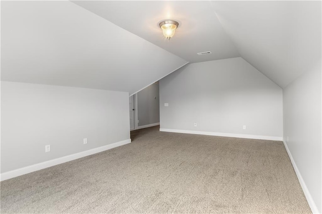 additional living space featuring carpet and lofted ceiling