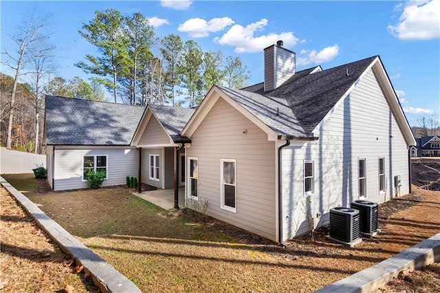 view of front of property with central AC unit, a patio, and a front lawn