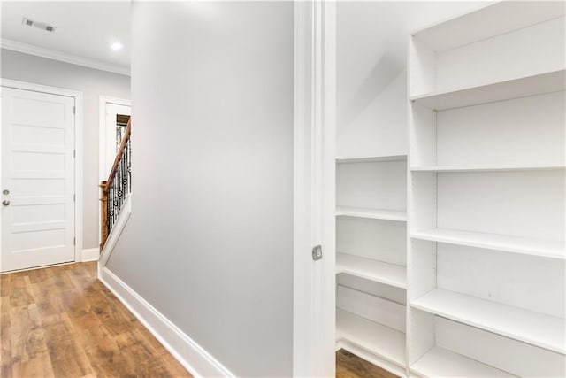 hall featuring wood-type flooring and crown molding