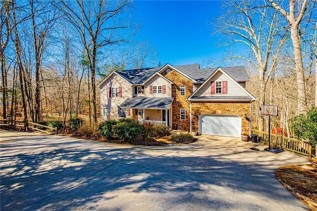 view of front of home featuring stone siding, a porch, concrete driveway, and a garage