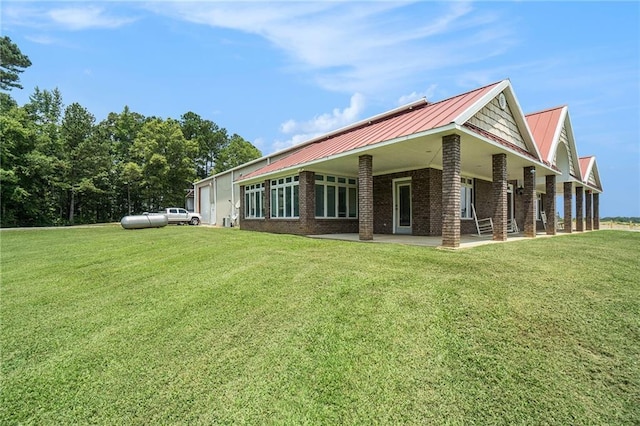 231 Gordon Rd, Cedartown, GA 30125 - view of property exterior with a lawn, brick siding, a patio area, and a metal roof