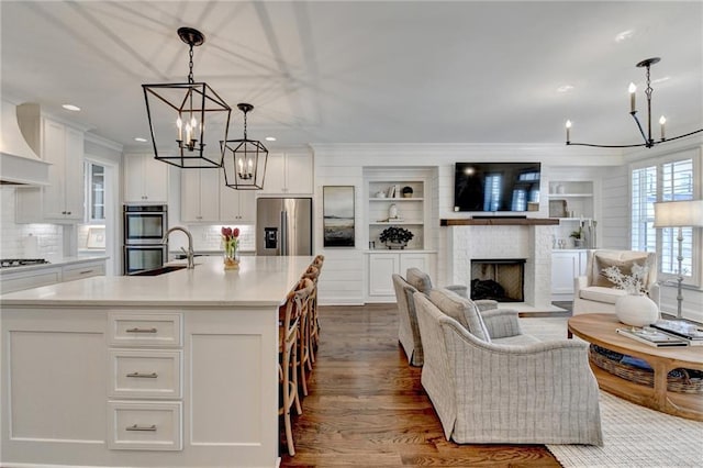 kitchen featuring appliances with stainless steel finishes, white cabinetry, and an inviting chandelier