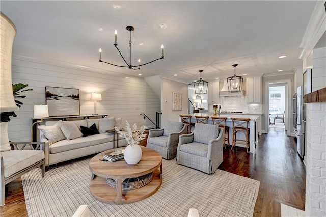 living area with ornamental molding, recessed lighting, a chandelier, and dark wood finished floors