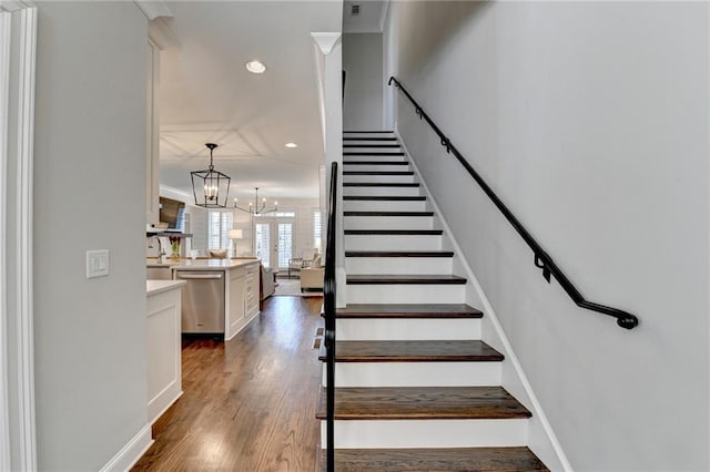 stairs featuring a notable chandelier, crown molding, wood finished floors, and recessed lighting