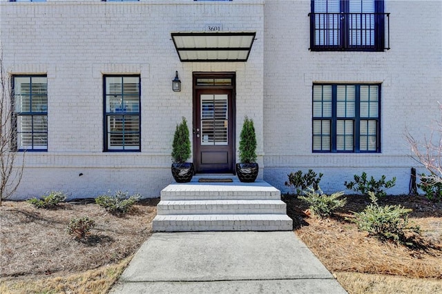 entrance to property featuring brick siding