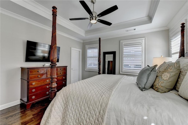 bedroom with a raised ceiling, visible vents, crown molding, and dark wood-style flooring