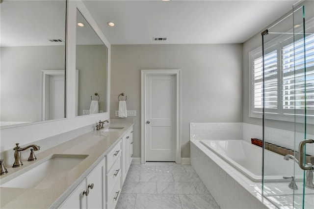 bathroom featuring marble finish floor, visible vents, a sink, and a bath