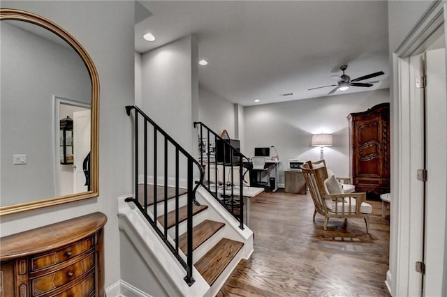 stairs with arched walkways, recessed lighting, wood finished floors, a ceiling fan, and baseboards