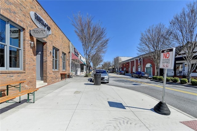 view of street with sidewalks, traffic signs, and curbs