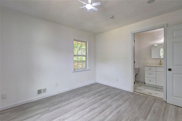 6454 Boca Grande Blvd, Forest Park, GA 30297 - unfurnished bedroom with light wood-style flooring, baseboards, connected bathroom, a textured ceiling, and a ceiling fan
