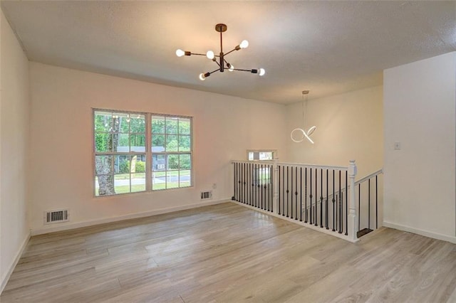 6454 Boca Grande Blvd, Forest Park, GA 30297 - unfurnished room with a chandelier, light wood finished floors, and baseboards