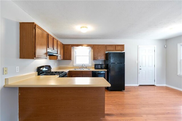 37 Indian Hills Ct, Dallas, GA 30157 - kitchen with extractor fan, a peninsula, light countertops, brown cabinets, and black appliances