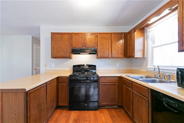37 Indian Hills Ct, Dallas, GA 30157 - kitchen featuring light countertops, a sink, a peninsula, under cabinet range hood, and black appliances
