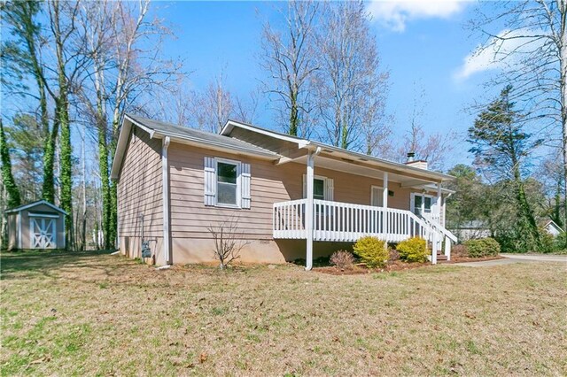37 Indian Hills Ct, Dallas, GA 30157 - view of front of property with covered porch, an outdoor structure, a shed, a chimney, and a front yard