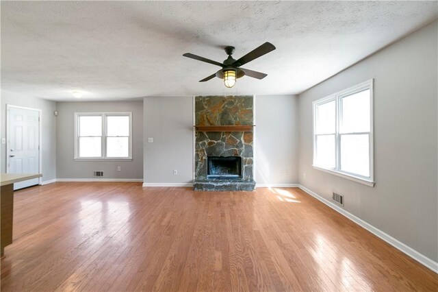 37 Indian Hills Ct, Dallas, GA 30157 - unfurnished living room with a textured ceiling, a fireplace, visible vents, and light wood-style floors